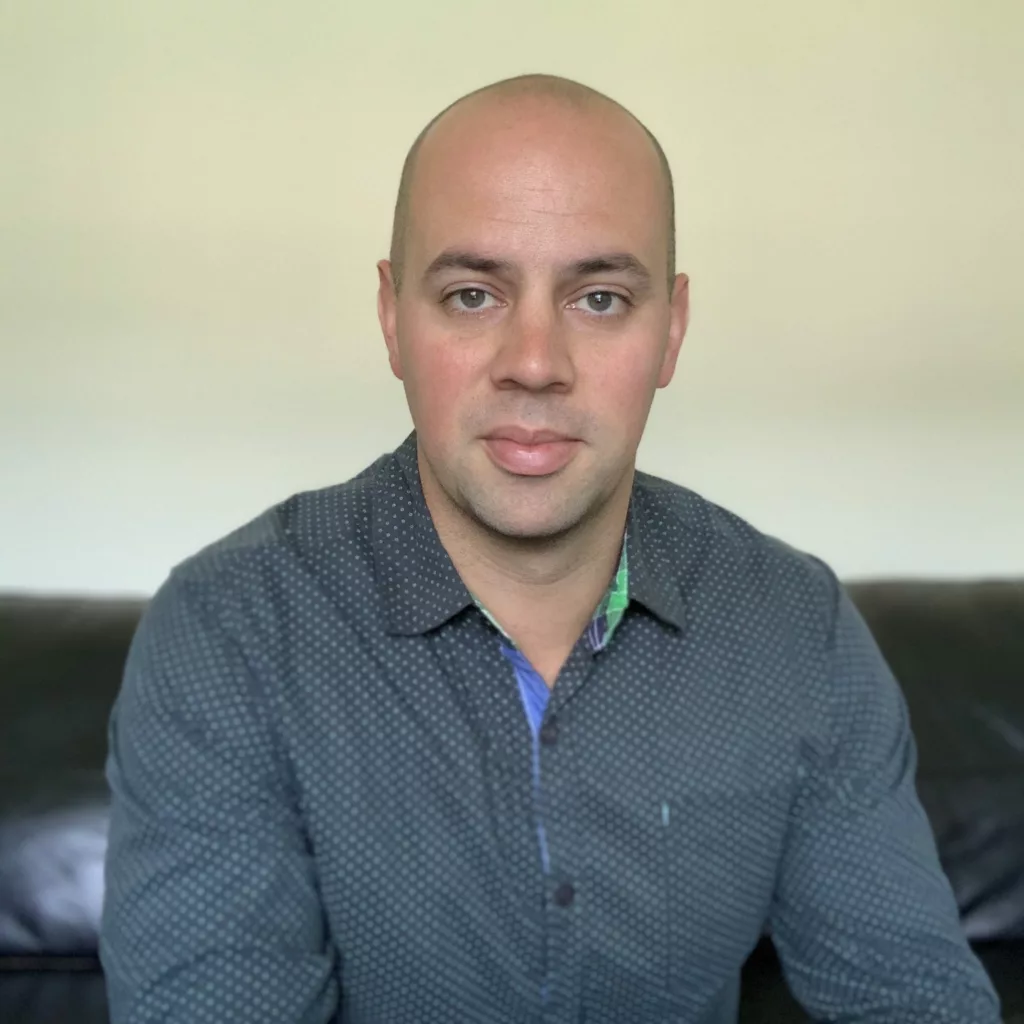 Kyle Wilson, professional Kelowna Mortgage Broker, sitting in his Kelowna office with a confident smile.